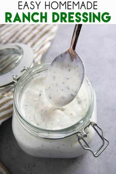 a spoon full of yogurt sitting on top of a glass jar filled with liquid