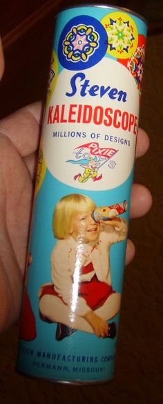 a hand holding a can of seven kaleidoscope milk on a wooden table