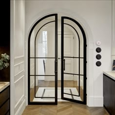 an arched glass door in a white room