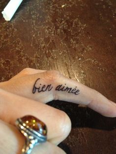 someone is holding their finger with the word'free annie'tattooed on it