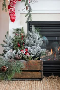 a wooden box filled with christmas decorations next to a fireplace