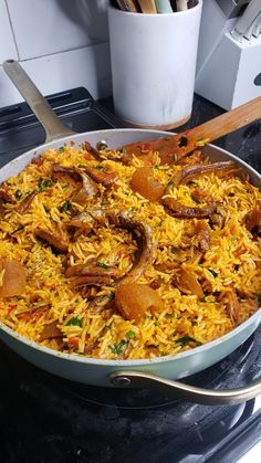 a large pan filled with food on top of a stove next to utensils