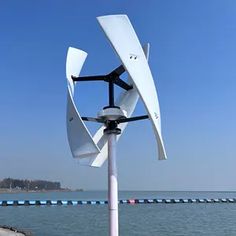 a white wind turbine sitting on top of a pier