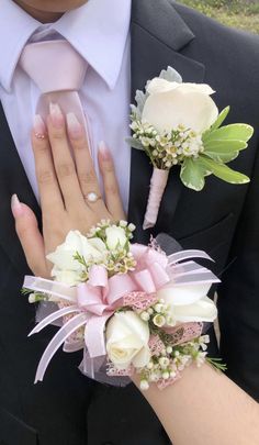 the bride and groom are wearing matching boutonnieres with their wedding bouquets