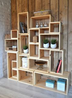 a wooden shelf filled with lots of shelves next to a brick wall and potted plants