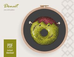 a cross stitch pattern with a donut in the shape of a face on it