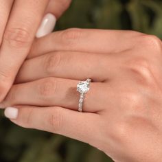 a woman's hand holding an engagement ring