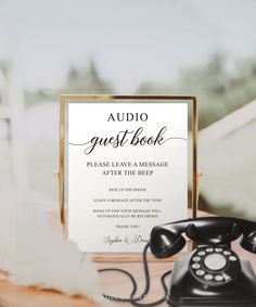 an old fashioned phone sitting on top of a table next to a sign that says guest book