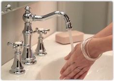 a person washing their hands under a faucet