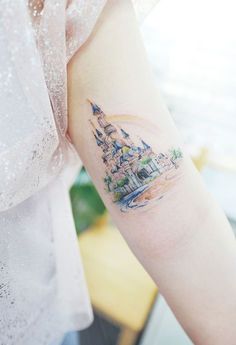 a woman's arm with a castle tattoo on the left side of her arm