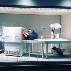 a display case with various items on it in a store window, including an umbrella and other accessories