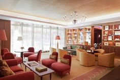 a living room filled with lots of furniture next to a window covered in bookshelves