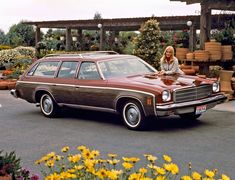 a woman standing next to a brown station wagon