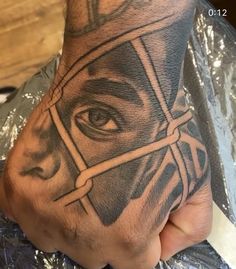 a man's hand with a tattoo on it and an eye in the middle