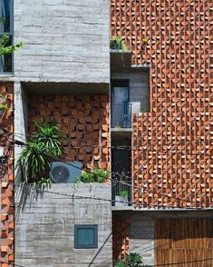 an apartment building made out of bricks with plants growing on the balconies