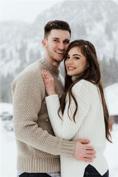 a man and woman hugging in the snow