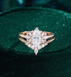 a diamond ring sitting on top of a green velvet covered cushioned surface with diamonds surrounding it