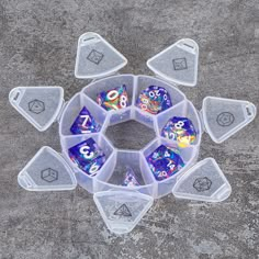 several plastic dice holders sitting on top of a cement surface with numbers and symbols in them