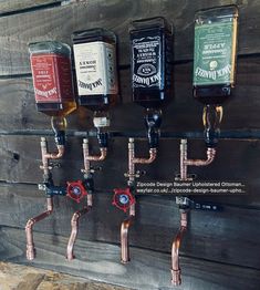 several bottles are hanging on the wall with copper pipes