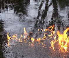 the fire is burning in the middle of the street and it looks like it's coming out of the water