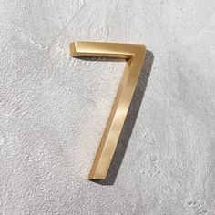 the number seven is shown in gold on a white surface with no one around it