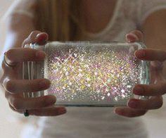 a woman holding up a glass case with glitter on it's sides and hands