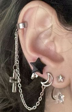 a close up of a person with ear piercings and chains on their ears,