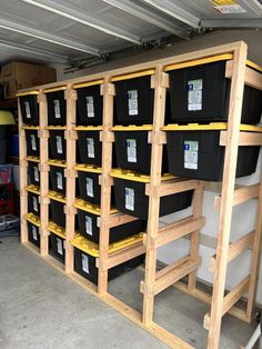 storage shelves filled with black and yellow plastic bins in a garage or office area