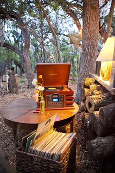 an old radio sitting on top of a wooden table next to a forest filled with trees