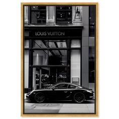 a black sports car parked in front of a louis vuitton store