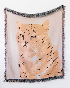 a cat tapestry hanging on the wall with fringes around it's edges and eyes