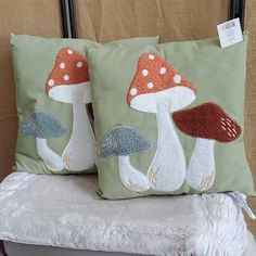 two decorative pillows with mushrooms on them