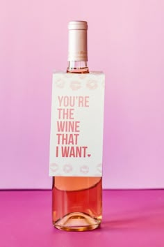 a bottle of wine that is sitting on a pink surface with the words you're the wine that i want