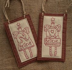 two small tags with the words believe and an angel on them hanging from twine strings