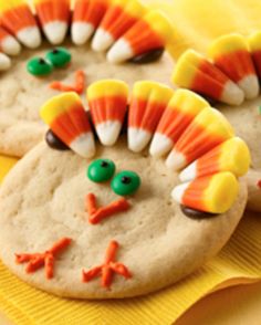 cookies decorated to look like a turkey with candy eyes and nose on yellow napkins