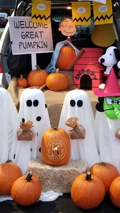 a group of halloween decorations in the back of a car with ghost figures and pumpkins