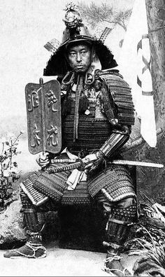 an old photo of a man dressed in traditional japanese garb sitting on a bench