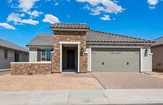 a house with two garages in front of it and blue sky behind the house