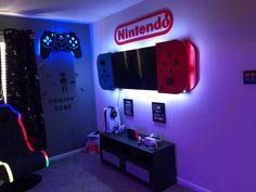 a gaming room with neon lights and a video game controller on the wall next to it