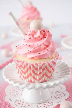 a cupcake with pink frosting on a plate