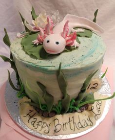 a birthday cake decorated with flowers, leaves and a unicorn figure on the top tier