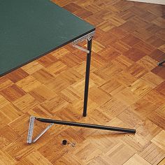 a green table sitting on top of a hard wood floor