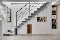 the stairs in this modern home are made of metal and wood, with bookshelves on either side