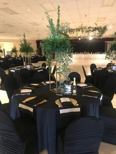 the tables are set up with black linens and centerpieces for an event