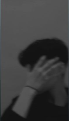 a blurry photo of a person covering their face