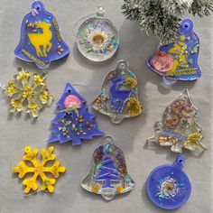 twelve glass ornaments are arranged on a table next to a christmas tree and snowflakes