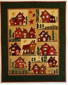 a quilted wall hanging with houses and trees on it's sides, in the middle