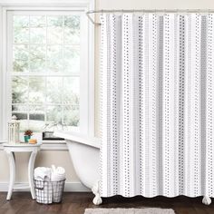 a bathroom with a tub, shower curtain and rug in front of the bathtub