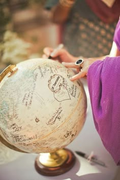 a person writing on an old globe