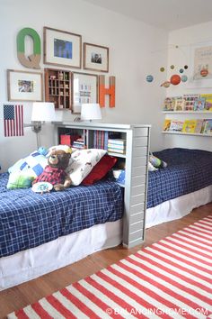 a bedroom with two twin beds and pictures on the wall above them, along with a rug